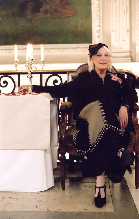photo de l'actrice bernadette lafont assise dans un fauteuil.