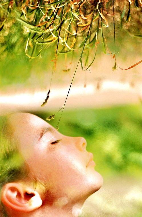 photo couleur en double impression d'un visage d'enfants et de brins d'herbes.