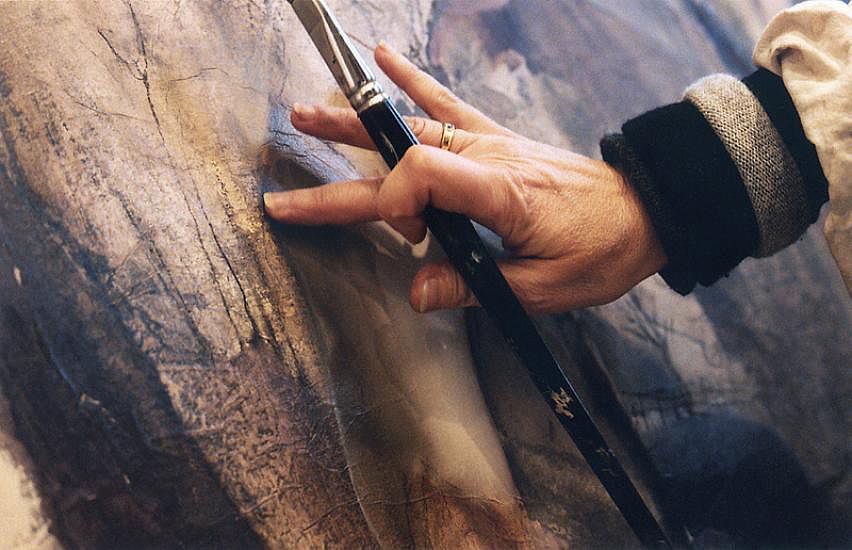 Photo en plan serré sur la main d'une artiste peintre.