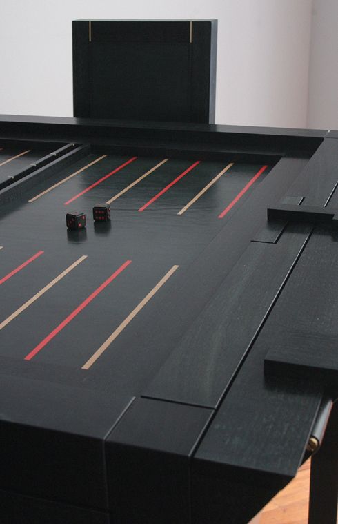 Photo d'une table de jeu de backgammon gainée de cuir noir par l'artisan Deuce.