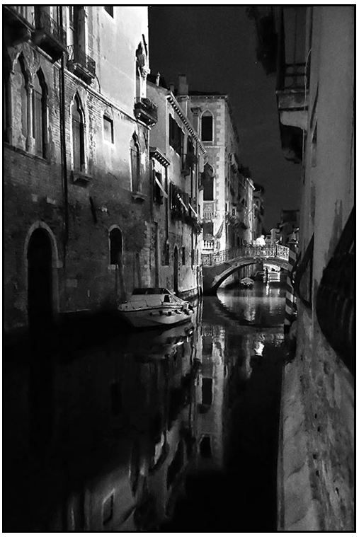 photo noir et blanc d'un canal dans venise la nuit