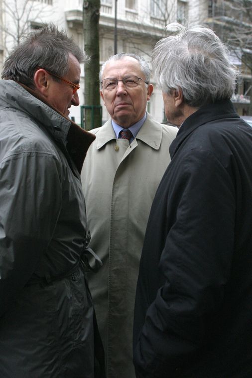 Photo de jacques delors debout entouré de deux personnes.