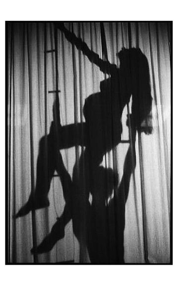 Photo noir et blanc en ombre chinoise femme enceinte sur un trapèze.