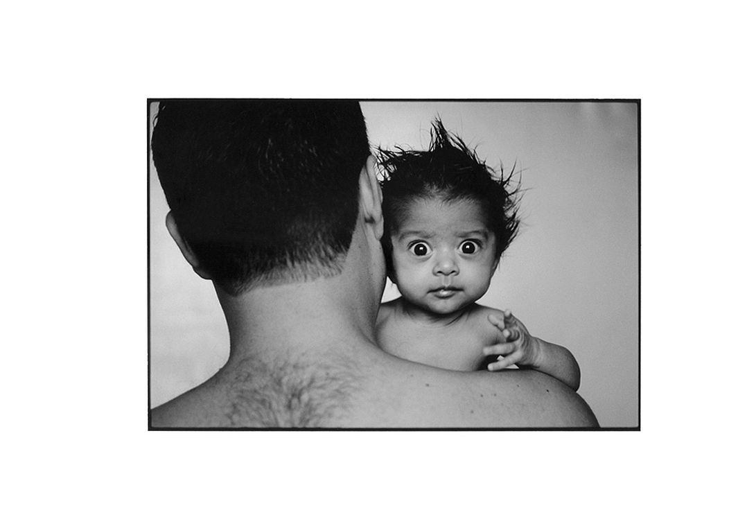 Photo noir et blanc d'un bébé sur l'épaule de son père.