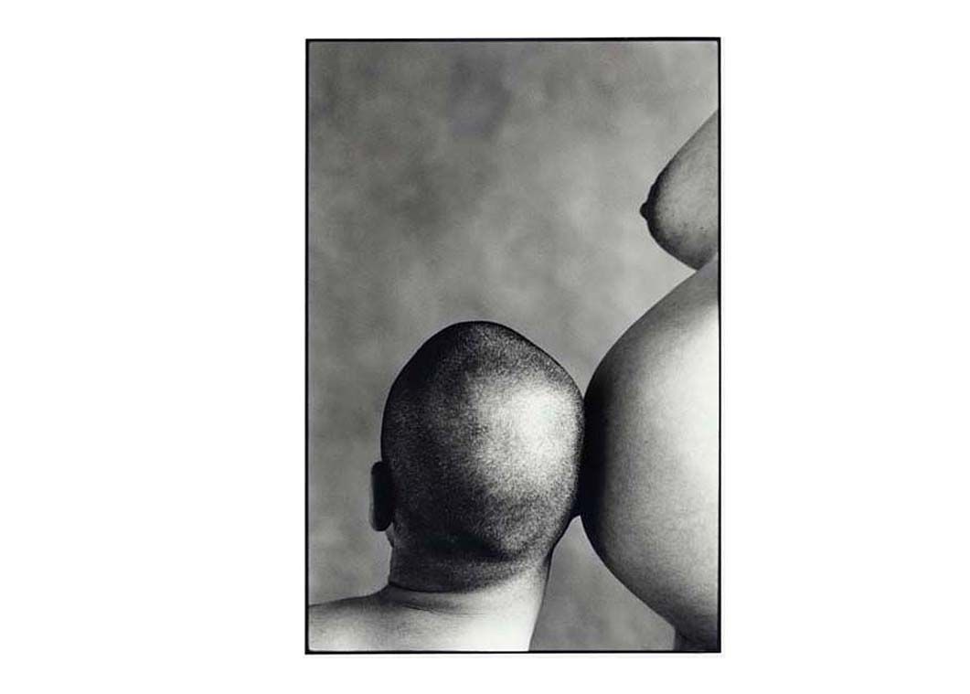 Photo noir et blanc d'un futur père écoutant le ventre de sa femme enceinte.