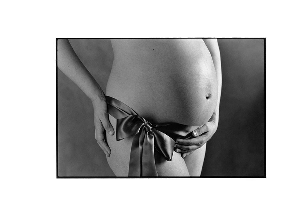 Photo artistique femme enceinte avec un ruban autour de la taille.