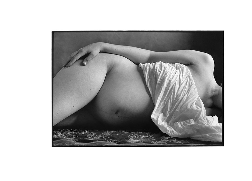 Photo artistique noir et blanc femme enceinte allongée avec un drapé.
