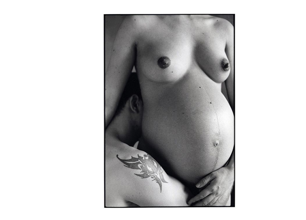 Photo artistique noir et blanc femme enceinte et conjoint avec tatouage.